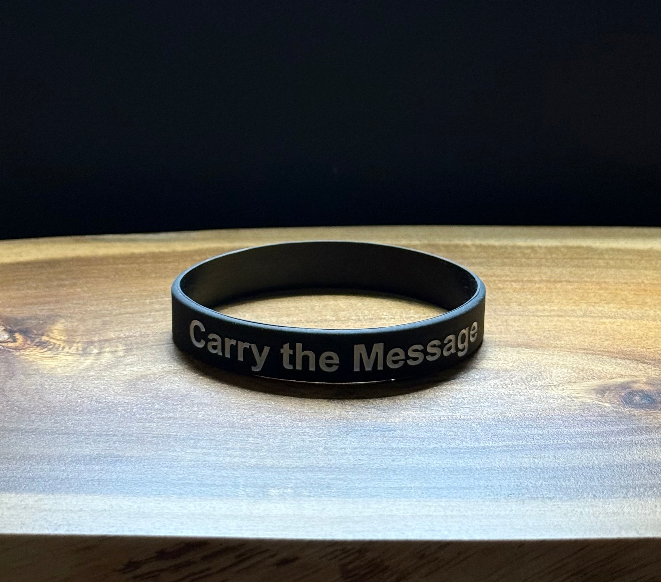 Black silicon wristband with 'Carry the Message' text