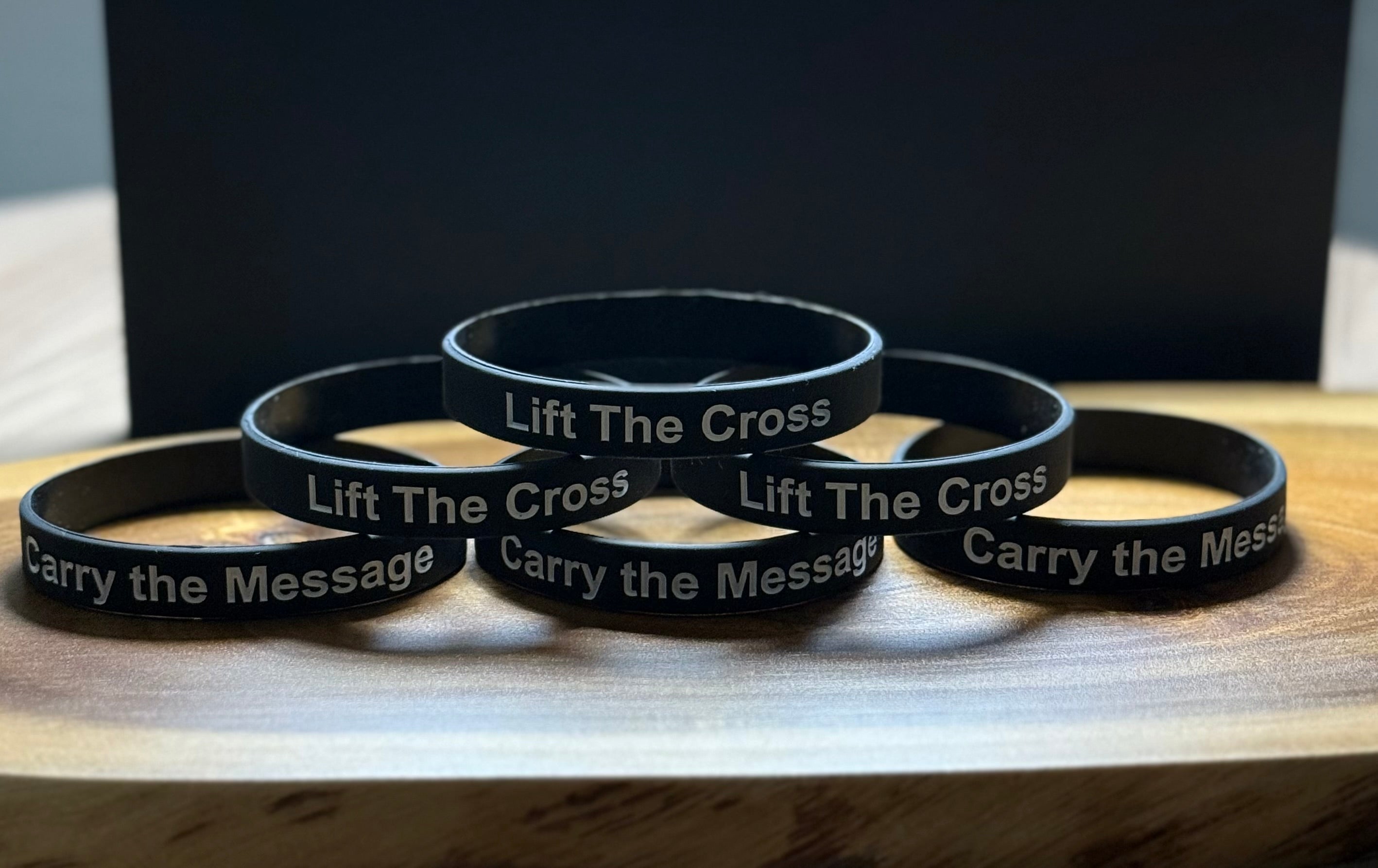 Black silicon wristbands with 'Carry the Message' and 'Lift The Cross' text in pyramid form
